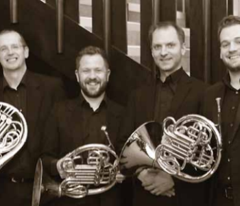 four men holding trumpets
